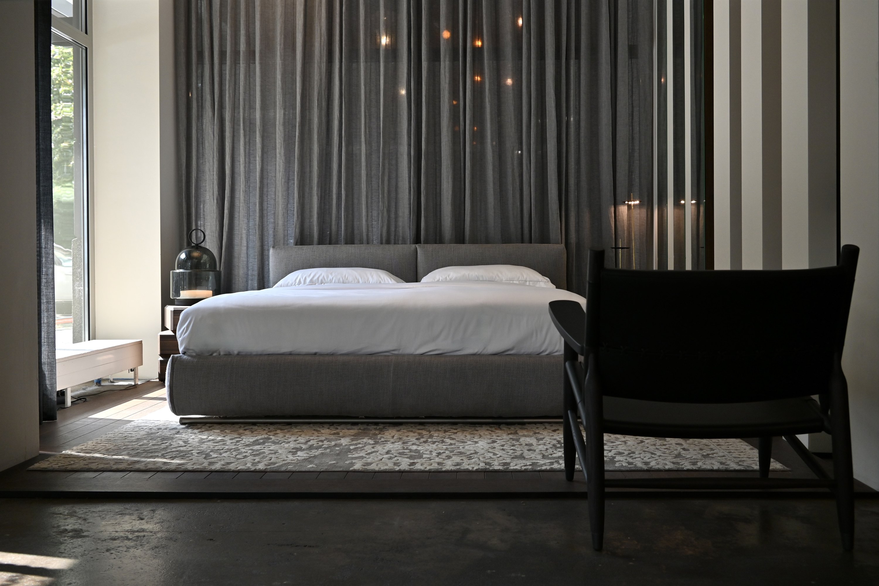 Bett mit Vorhang und Sessel im Schlafbereich